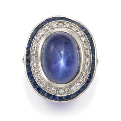un gros plan sur une bague sertie d'un saphir étoilé bleu et de diamants