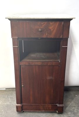 a small wooden cabinet with a marble top on the floor