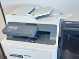 une imprimante posée sur un bureau à côté d'une imprimante