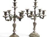 une paire de chandeliers en métal argenté ornés de fleurs et de feuilles