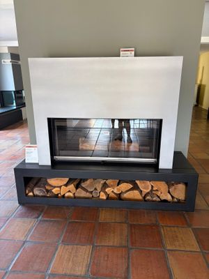 a fireplace with logs stacked on it in the middle of a room