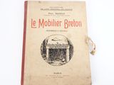 un vieux livre posé sur une table à côté d'un mur blanc