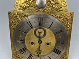 une horloge dorée et argentée posée sur une surface blanche