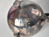 a small silver object on a white surface