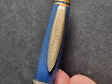 a person holding a blue pen in their hand