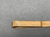 a gold tie bar that is on a table