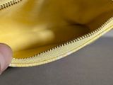 a person holding a gold purse with a coin inside of it