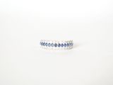 a close up of a blue and white diamond ring on a white surface