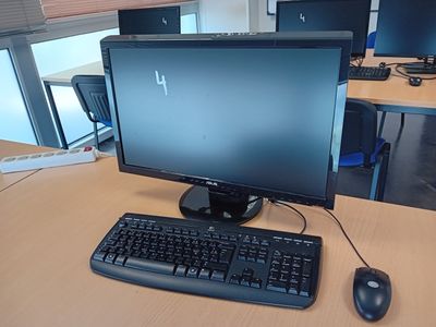 une photo d'un bureau d'ordinateur avec un clavier et un écran