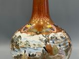 a vase with a painting on it sitting on a table