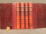 three red books sitting on top of each other on a table
