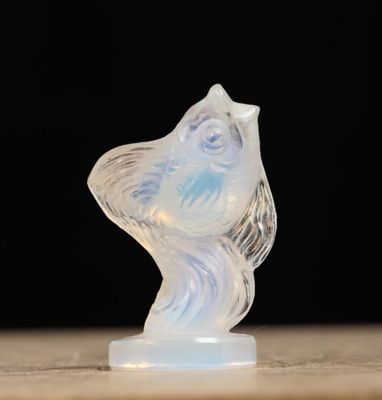une sculpture en verre représentant un oiseau, posée sur une table