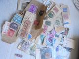 une pile de timbres posée sur une table, avec des ciseaux et une paire de ciseaux