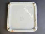 une assiette blanche aux bords bruns posée sur une table
