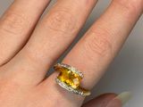 yellow sapphire and diamond ring on a woman ' s hand