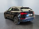 the rear end of a black audi suv parked in a showroom