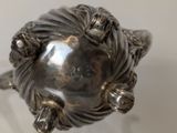 a silver ring with a face on top of it