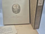 un livre ouvert posé sur une table, à côté de deux autres livres