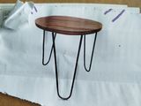 une petite table aux pieds en épingle à cheveux posée sur une feuille de papier