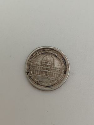 une pièce d'argent sur laquelle figure l'image d'un bâtiment