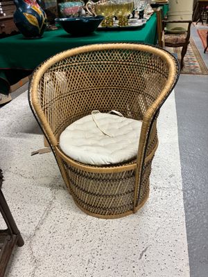 une chaise en osier avec un coussin posé dessus, dans un magasin