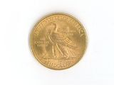 a gold coin with a bird on it on a white surface