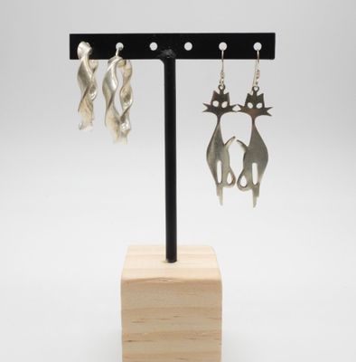 un gros plan sur une paire de boucles d'oreilles posées sur un support en bois