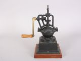 antique cast iron coffee grinder on wooden base with wooden handle