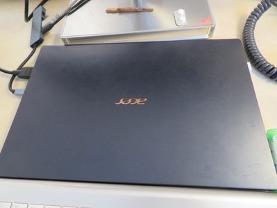 un ordinateur portable posé sur un bureau, à côté d'un clavier