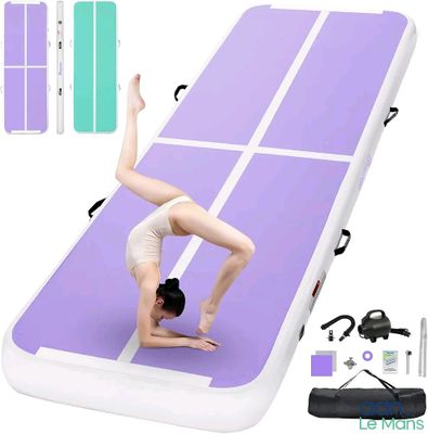 tapis de gymnastique gonflable violet et blanc sur lequel figure une femme faisant le poirier