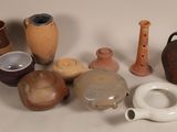 many different types of pottery sitting on a table