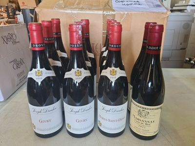 six bouteilles de vin rouge sont alignées sur une table