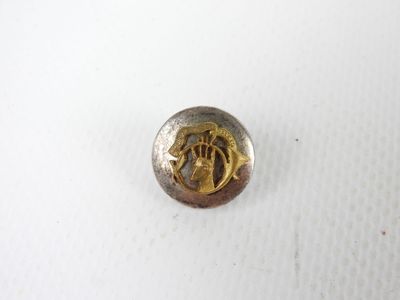 a close up of a metal button with a horse on it