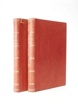 two red books sitting on top of each other on a white surface