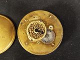 a gold pocket watch with a gold dial and a gold case