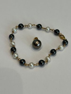un gros plan sur un bracelet orné d'une perle noire et blanche