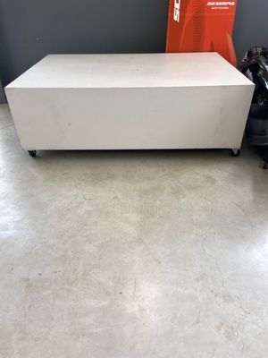 une photo d'une table basse blanche posée sur un parquet en bois massif