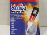 un gros plan d'un tube de colle posé sur une surface blanche