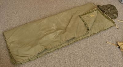 a sleeping bag on the floor next to a pair of scissors