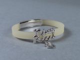 un bracelet blanc sur lequel est inscrit le mot « love »