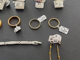 many different types of rings and bracelets on the table