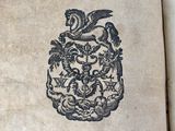 an old book with a picture of a coat of arms on it