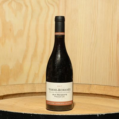 a bottle of wine sitting on top of a barrel