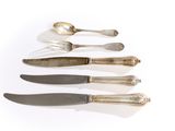 several different types of knives and spoons on a white surface