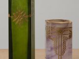 a green and purple vase next to a green and gold box