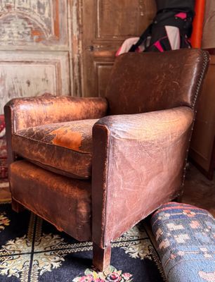 a brown leather chair sitting on a rug in a living room