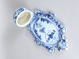 a blue and white plate with a cup and saucer
