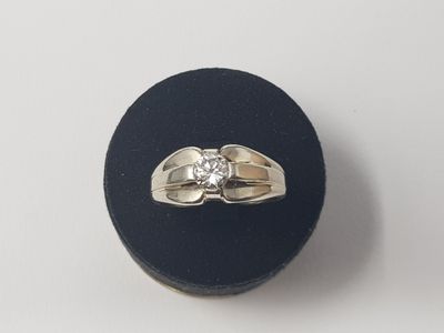 une photo d'une bague en diamant posée sur un présentoir noir