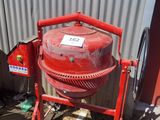 une bétonnière rouge garée devant un immeuble