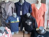 several mannequins and shirts on display in a clothing store